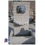 Stone granite wall fountain with lion head sculpture